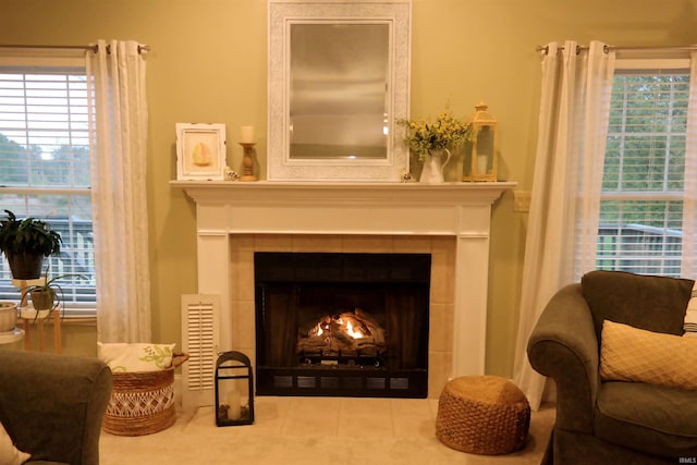 living area featuring a tile fireplace and visible vents