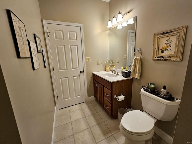 half bathroom featuring tile patterned floors, baseboards, vanity, and toilet