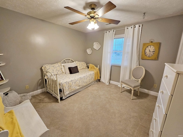 bedroom featuring baseboards, a ceiling fan, a textured ceiling, and light carpet