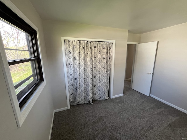 unfurnished bedroom featuring baseboards and carpet flooring
