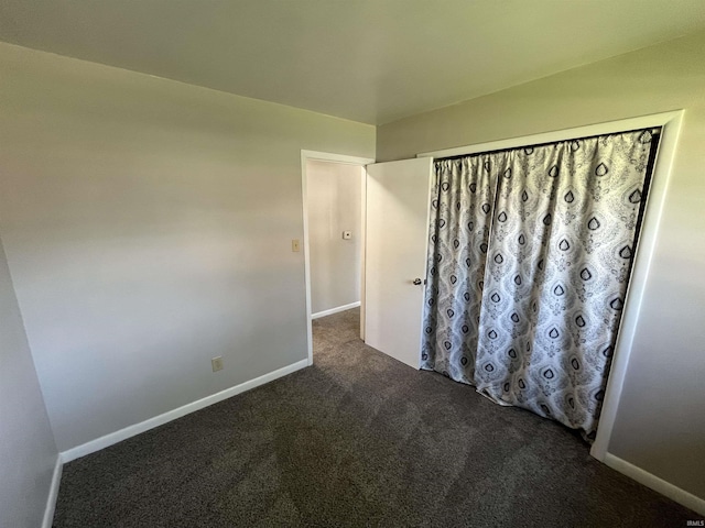 carpeted empty room with baseboards