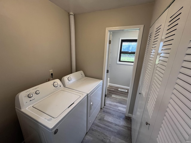 laundry room with laundry area, baseboards, dark wood-type flooring, visible vents, and independent washer and dryer