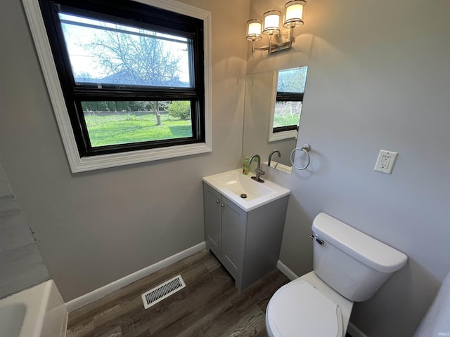 bathroom featuring toilet, baseboards, visible vents, a notable chandelier, and wood finished floors