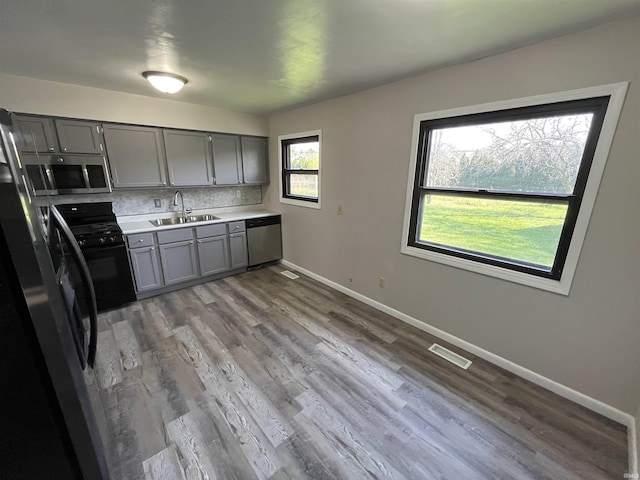 kitchen featuring a sink, visible vents, baseboards, gray cabinetry, and appliances with stainless steel finishes