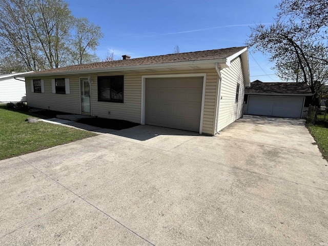 ranch-style home featuring driveway and a detached garage