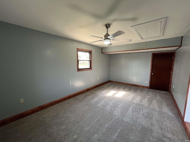 empty room with attic access, baseboards, a ceiling fan, and carpet flooring