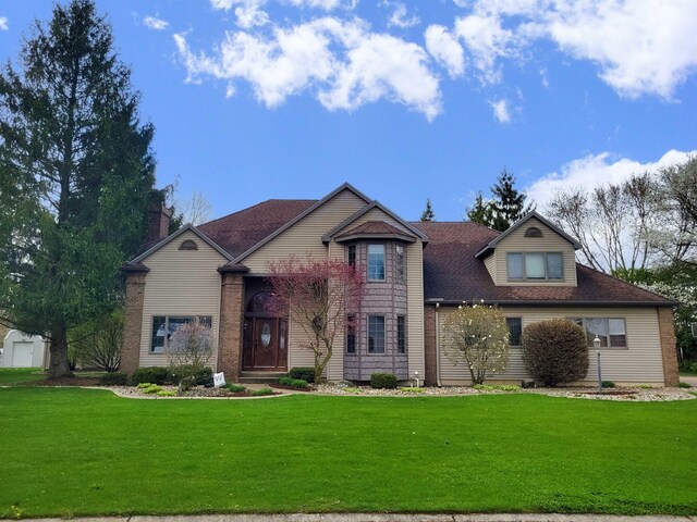 view of front of property featuring roof with shingles and a front yard