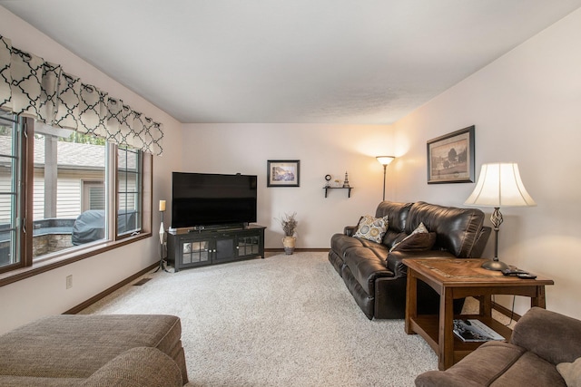 carpeted living room featuring visible vents and baseboards