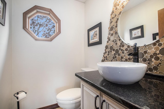 half bathroom featuring toilet and vanity