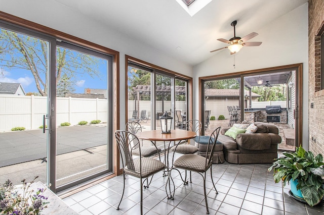 sunroom / solarium featuring tile patterned flooring, a wooden deck, and lofted ceiling