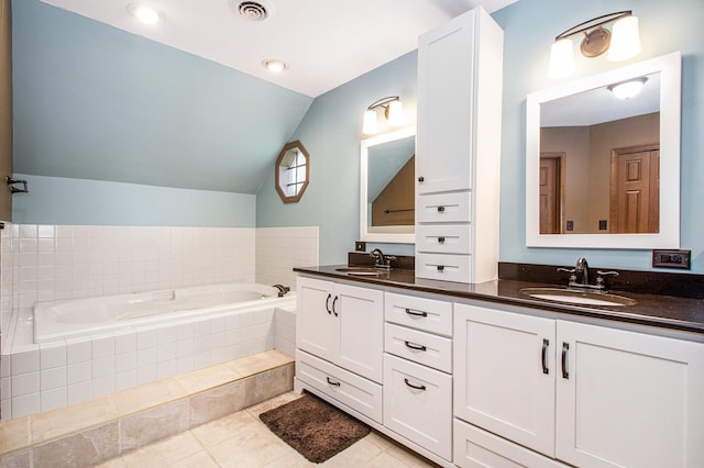 full bathroom with visible vents, a bath, vaulted ceiling, and a sink