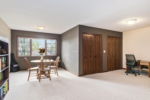 carpeted dining space featuring baseboards