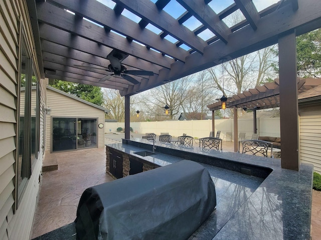 view of patio / terrace featuring a sink, a pergola, outdoor wet bar, fence, and area for grilling