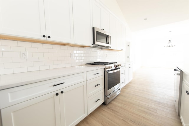 4026 W Carmola Dr, Bloomington, IN 47404 - kitchen featuring light countertops, decorative backsplash, light wood-style flooring, appliances with stainless steel finishes, and white cabinetry