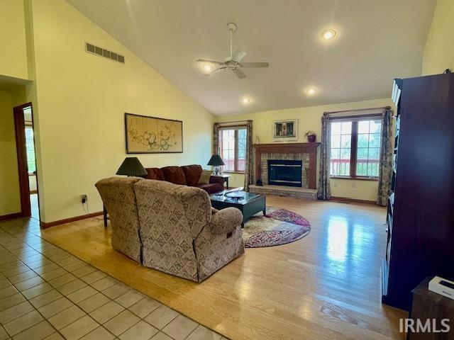 living area featuring visible vents, baseboards, ceiling fan, and light tile patterned floors
