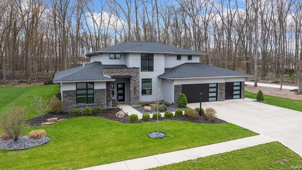 prairie-style house featuring stucco siding, an attached garage, driveway, stone siding, and a front yard