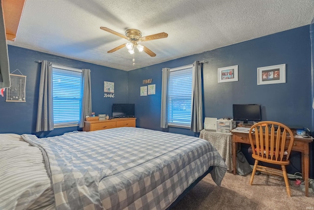 bedroom with ceiling fan, carpet flooring, and a textured ceiling