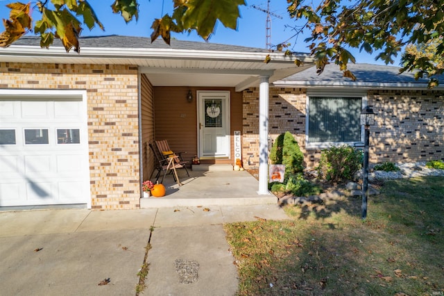 view of front of house featuring an attached garage, brick siding, and covered porch