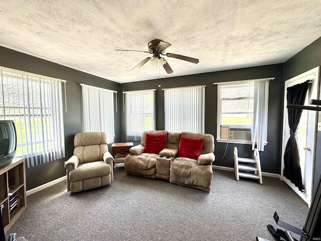 living room featuring carpet, a textured ceiling, a ceiling fan, and baseboards