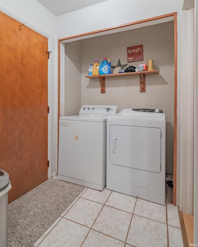 laundry area featuring separate washer and dryer, laundry area, and light tile patterned floors