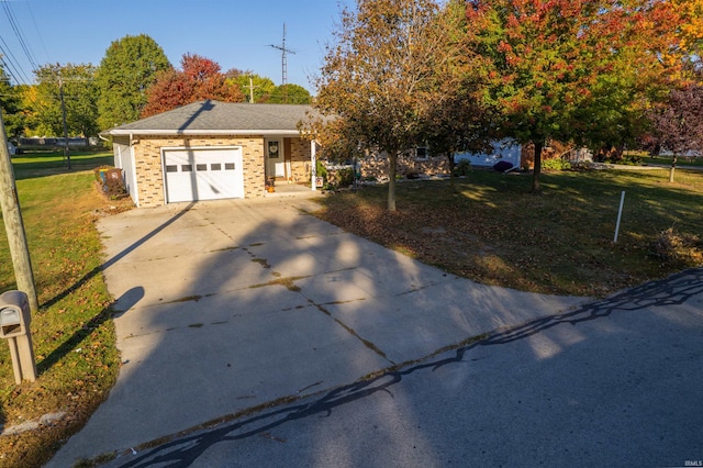 single story home with a garage, brick siding, a front yard, and concrete driveway
