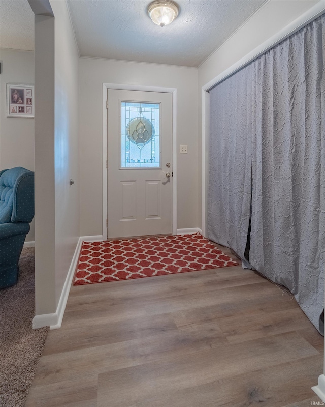 foyer entrance featuring baseboards and wood finished floors