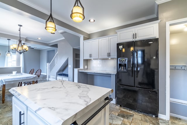 kitchen with black fridge, baseboards, backsplash, stone finish flooring, and crown molding