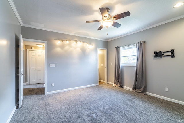 spare room with carpet, ornamental molding, and ceiling fan