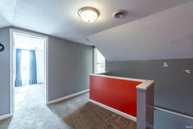 additional living space featuring baseboards, vaulted ceiling, visible vents, and carpet floors