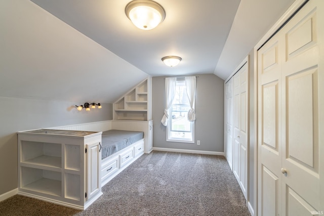 additional living space with lofted ceiling, dark colored carpet, and baseboards