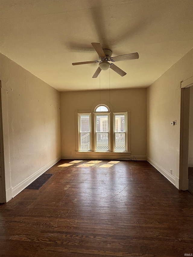 unfurnished room featuring baseboards, a ceiling fan, wood finished floors, and visible vents
