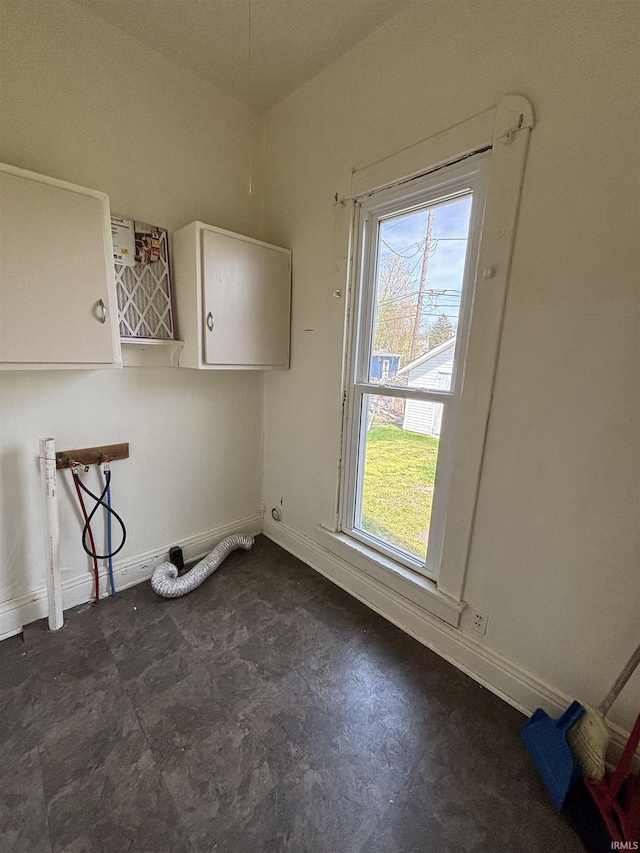 interior space featuring baseboards, washer hookup, and cabinet space