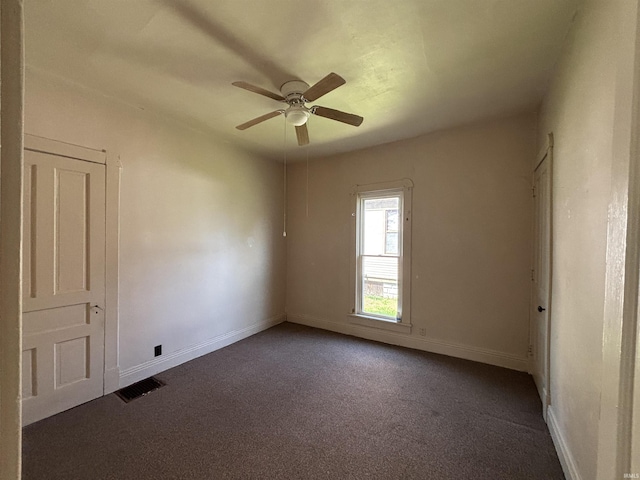 spare room featuring carpet flooring, baseboards, visible vents, and ceiling fan