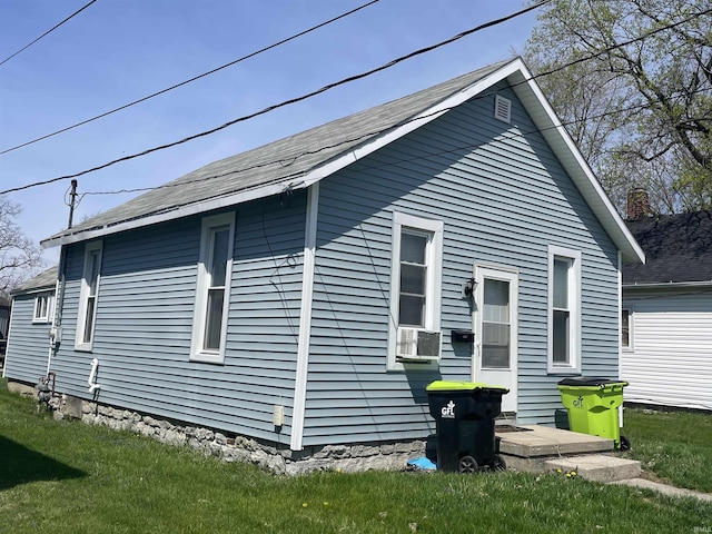 view of side of home with a lawn and cooling unit