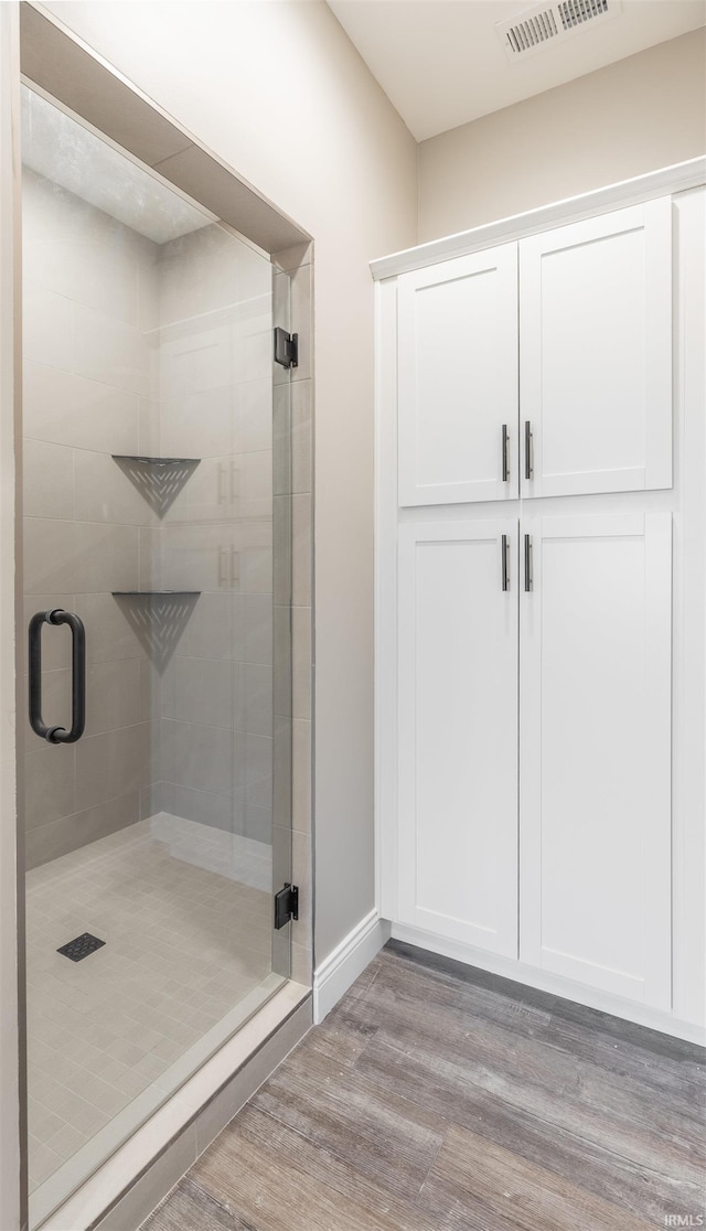 1033 Triple Crown Dr, Evansville, IN 47725 - full bathroom featuring baseboards, visible vents, a shower stall, and wood finished floors