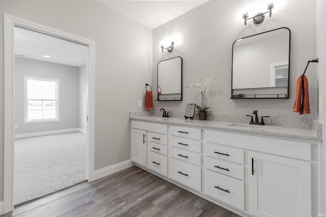 1033 Triple Crown Dr, Evansville, IN 47725 - bathroom with double vanity, baseboards, a sink, and wood finished floors