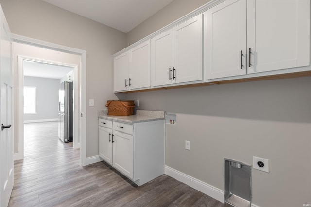 1033 Triple Crown Dr, Evansville, IN 47725 - laundry room with cabinet space, hookup for an electric dryer, baseboards, and wood finished floors