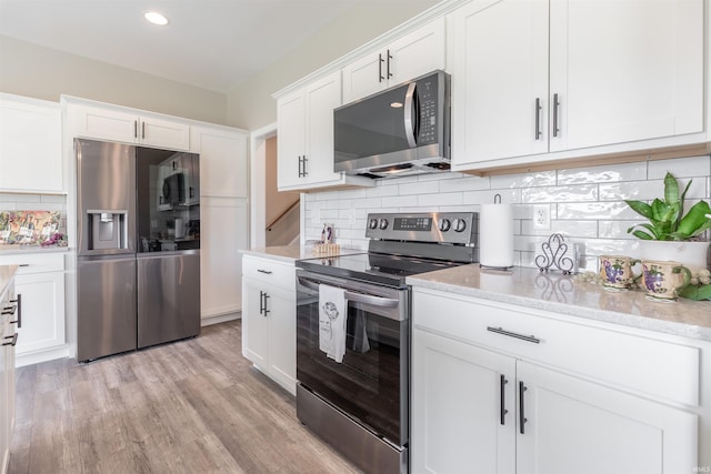 1033 Triple Crown Dr, Evansville, IN 47725 - kitchen with appliances with stainless steel finishes, tasteful backsplash, light stone countertops, and white cabinets
