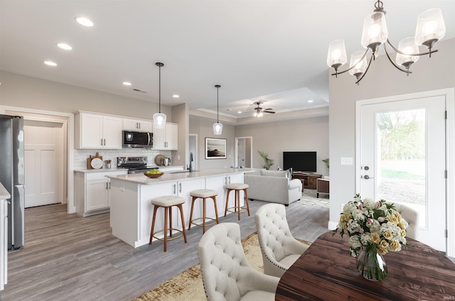 1033 Triple Crown Dr, Evansville, IN 47725 - dining room with visible vents, recessed lighting, a tray ceiling, light wood finished floors, and ceiling fan with notable chandelier