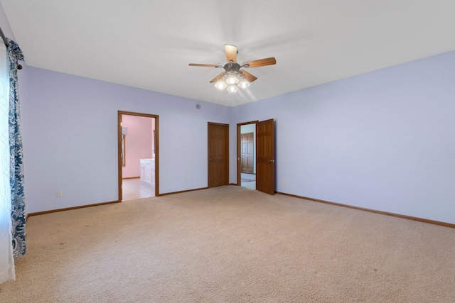 unfurnished bedroom with light carpet, ensuite bath, baseboards, and ceiling fan