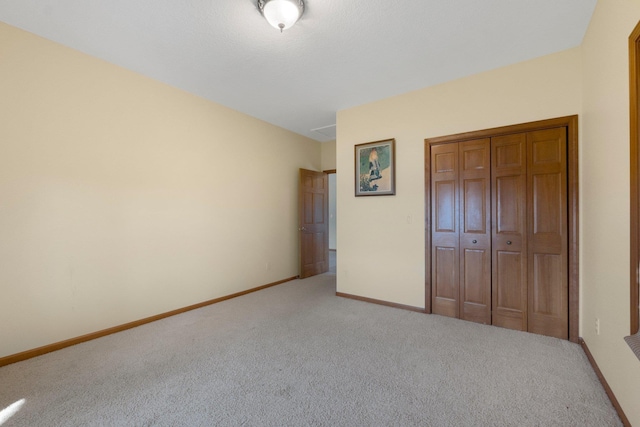 unfurnished bedroom with baseboards, a closet, and carpet