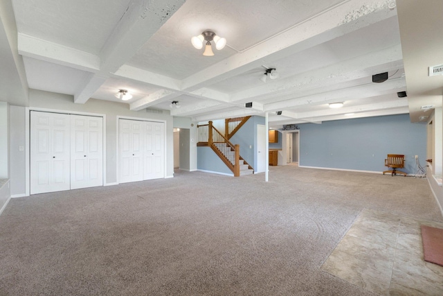 finished basement with stairway, visible vents, carpet flooring, and baseboards