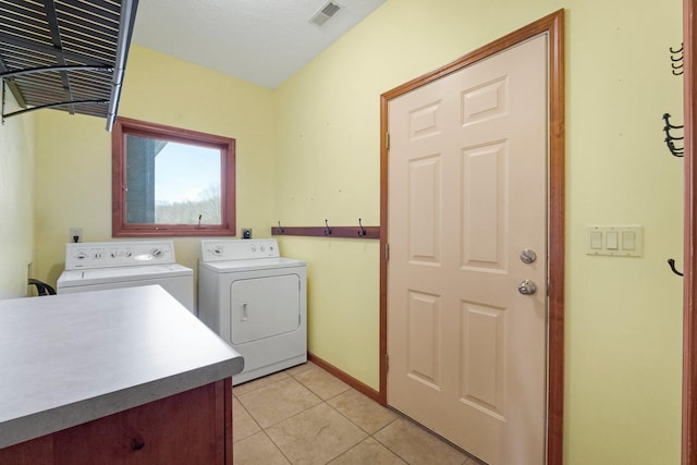 laundry area with washing machine and dryer, visible vents, light tile patterned flooring, and laundry area