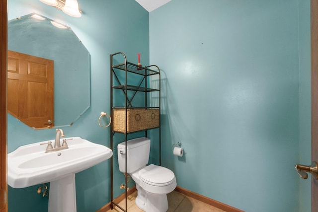 bathroom with baseboards, tile patterned flooring, and toilet