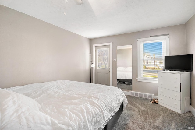 carpeted bedroom featuring baseboards, a ceiling fan, and visible vents