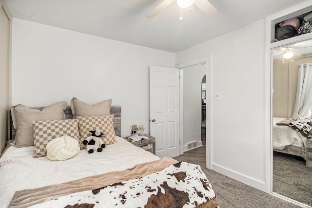 bedroom with a ceiling fan, arched walkways, baseboards, carpet flooring, and visible vents