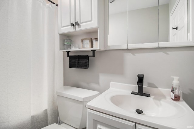 full bathroom with toilet, vanity, and curtained shower