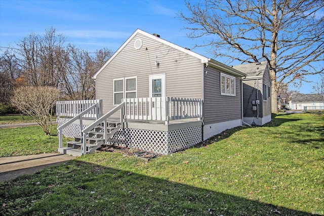 rear view of property with a lawn and a deck