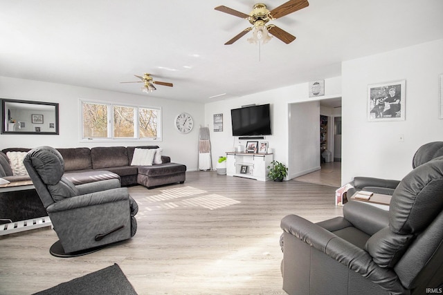 living room featuring a ceiling fan and light wood-type flooring