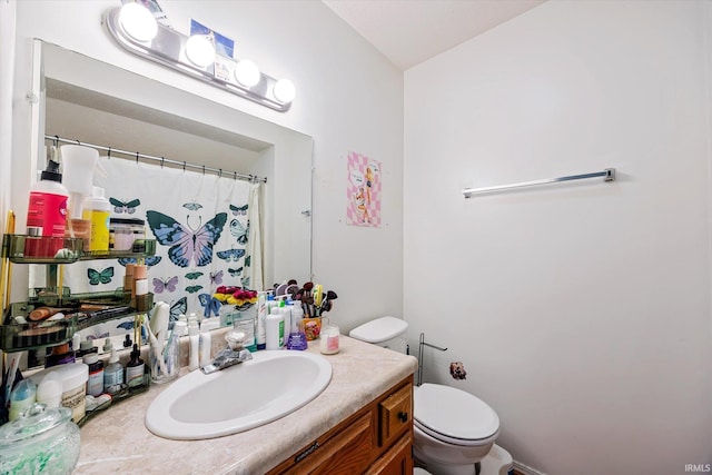 bathroom featuring toilet, a shower with shower curtain, and vanity